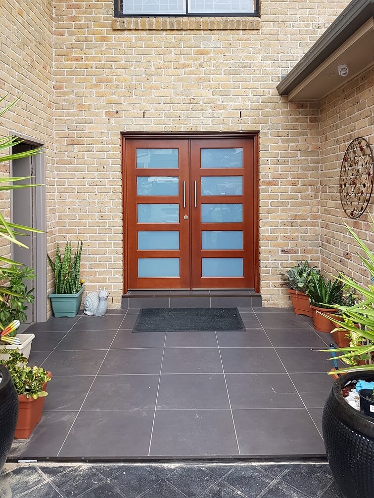 double frosted glass timber front entry doors on brick home