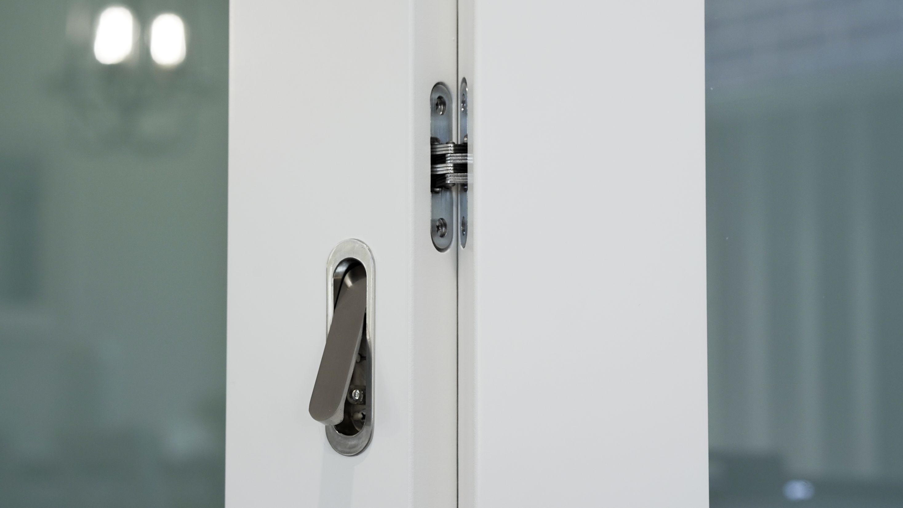 Pull handle with chrome finish on white door with translucent glass