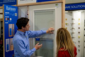 Doors Plus - Sales Consultant Showing Venetian Blinds with Magnetic Strip to Customer
