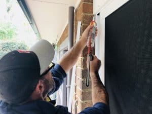 Doors Plus - Man Using Cauking Gun to Seal Any Door Gaps