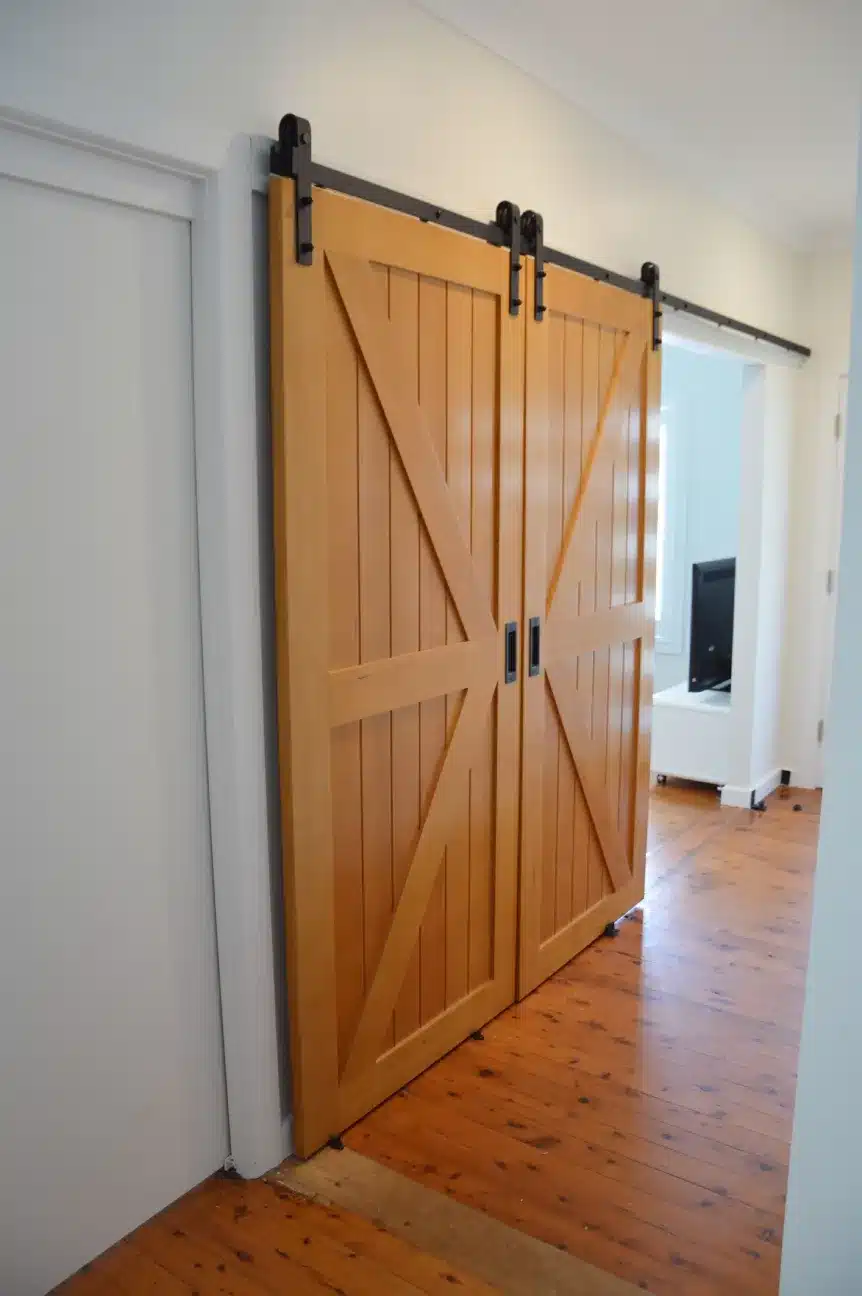 Doors Plus Internal Gelngary Barn Sliding double door Stained in light Maple with Black Barn long Tracks for your theatre room opened